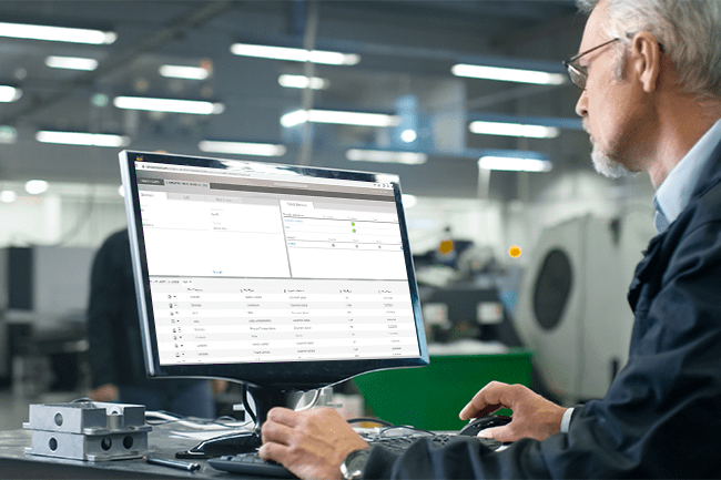 Man working on a desktop office computer using enterprise document software that makes records compliance easy.