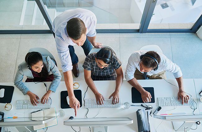 A team of four digital technology professionals on computers preforming a gap analysis.