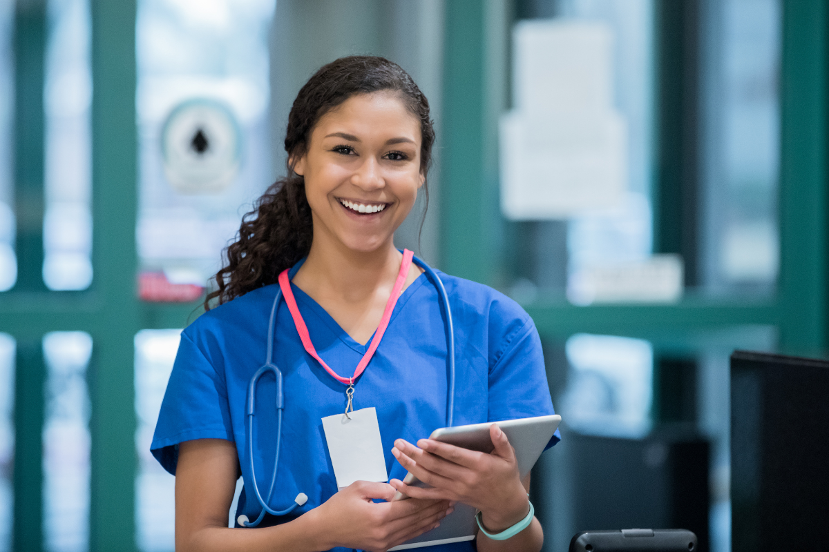 Smiling medical professional using a tablet in a hospital