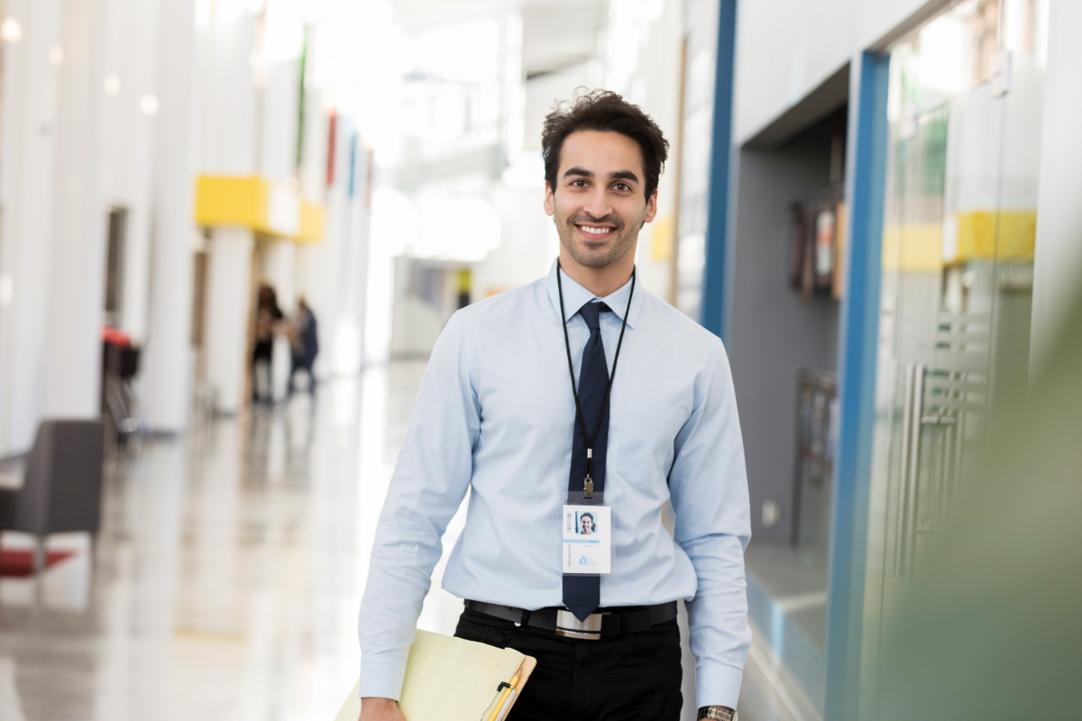 A teacher smiling in a hallway